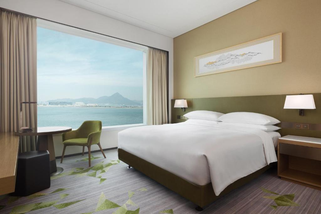 a bedroom with a large bed and a large window at Sheraton Hong Kong Tung Chung Hotel in Hong Kong