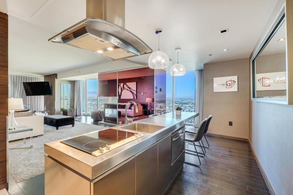 a kitchen with a counter and a living room at Vegas Palms HIGH 52nd fl. 1BDR corner penthouse 1220sqft in Las Vegas