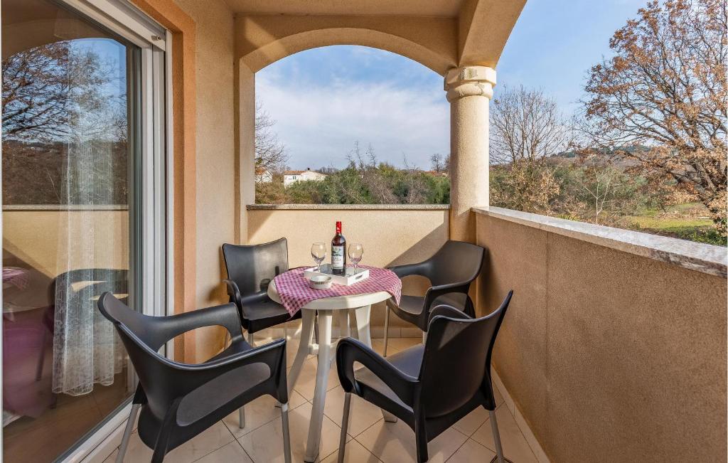 a small table and chairs on a balcony with a window at Lovely Apartment In Medulin With Kitchen in Medulin