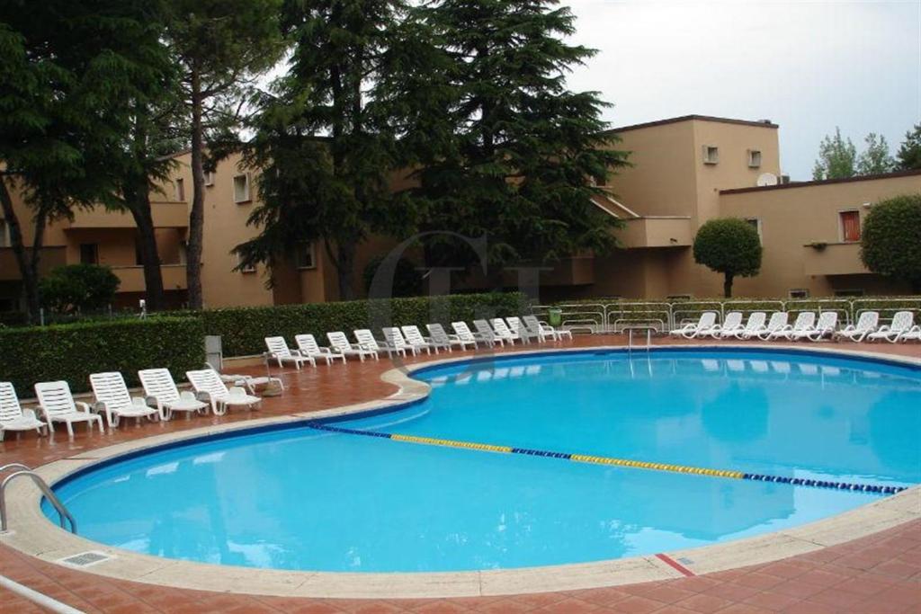 einem großen Pool mit Liegestühlen und einem Gebäude in der Unterkunft Vita Loca Apartments in Peschiera del Garda