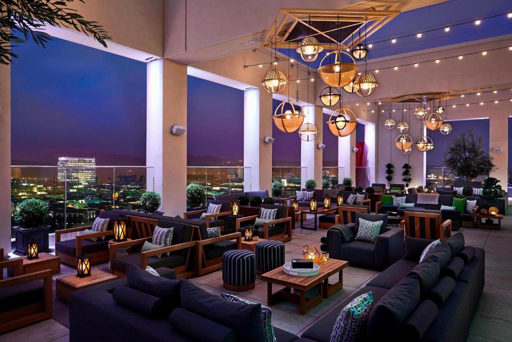 a hotel lobby with couches and tables and lights at Marriott Irvine Spectrum in Irvine