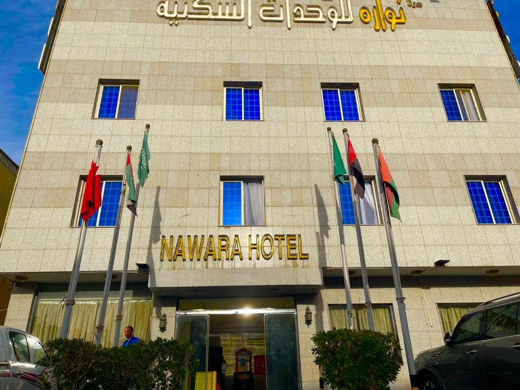a hotel with several flags in front of it at Nawara Hotel Khanshalila in Riyadh