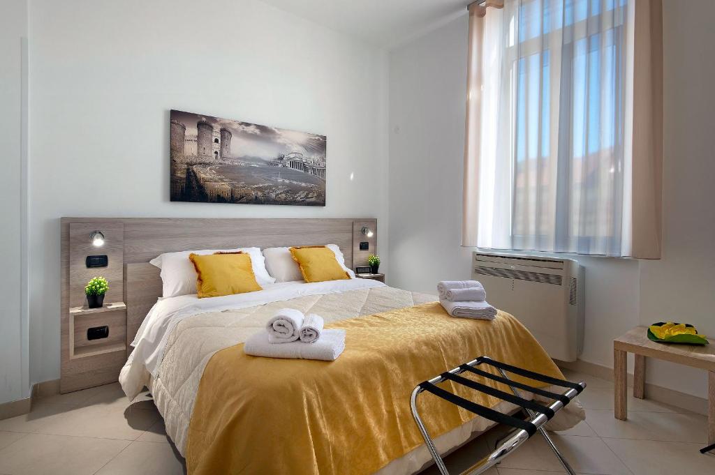 sypialnia z dużym łóżkiem z ręcznikami w obiekcie La Preziosa Apartment Duomo w mieście Napoli