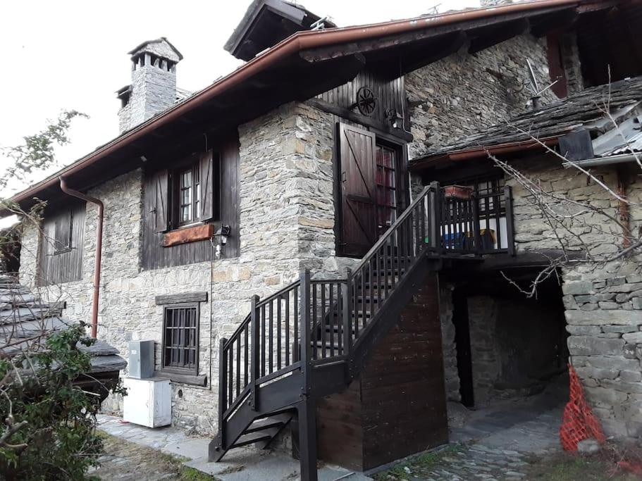 ein altes Steinhaus mit einer Treppe drauf in der Unterkunft Tana della volpe 1 in Gressan