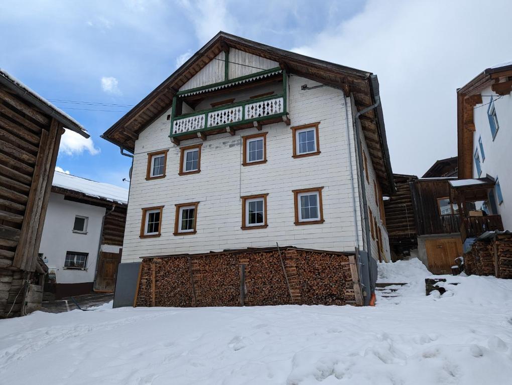 a white building with a sign on it in the snow at Ferienhaus Fatlar in Kappl