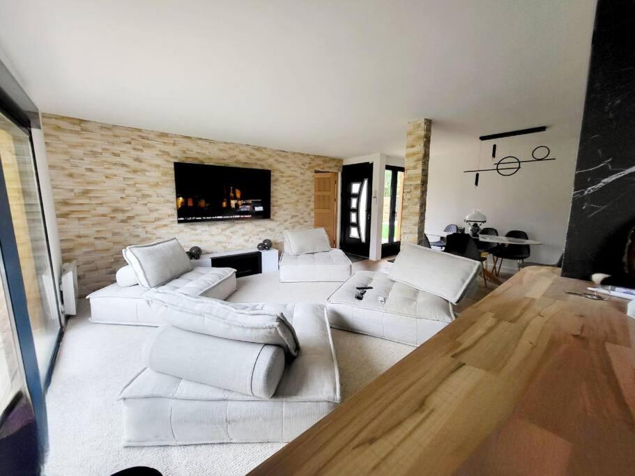 ein Wohnzimmer mit weißen Sofas und einem TV in der Unterkunft Maison 6 personnes base Nautique JO 2024 proche Disney Paris in Noisy-le-Grand