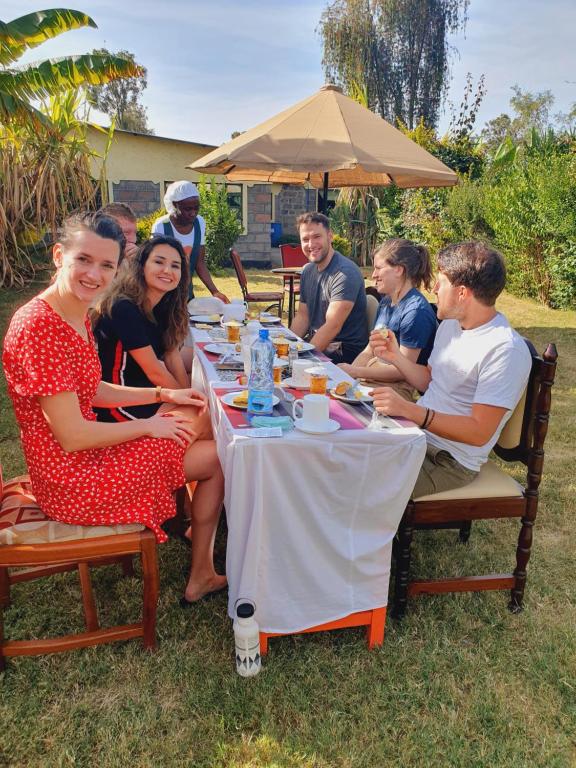 Un groupe de personnes assises autour d'une table dans l'établissement Homebase gardens, à Nakuru