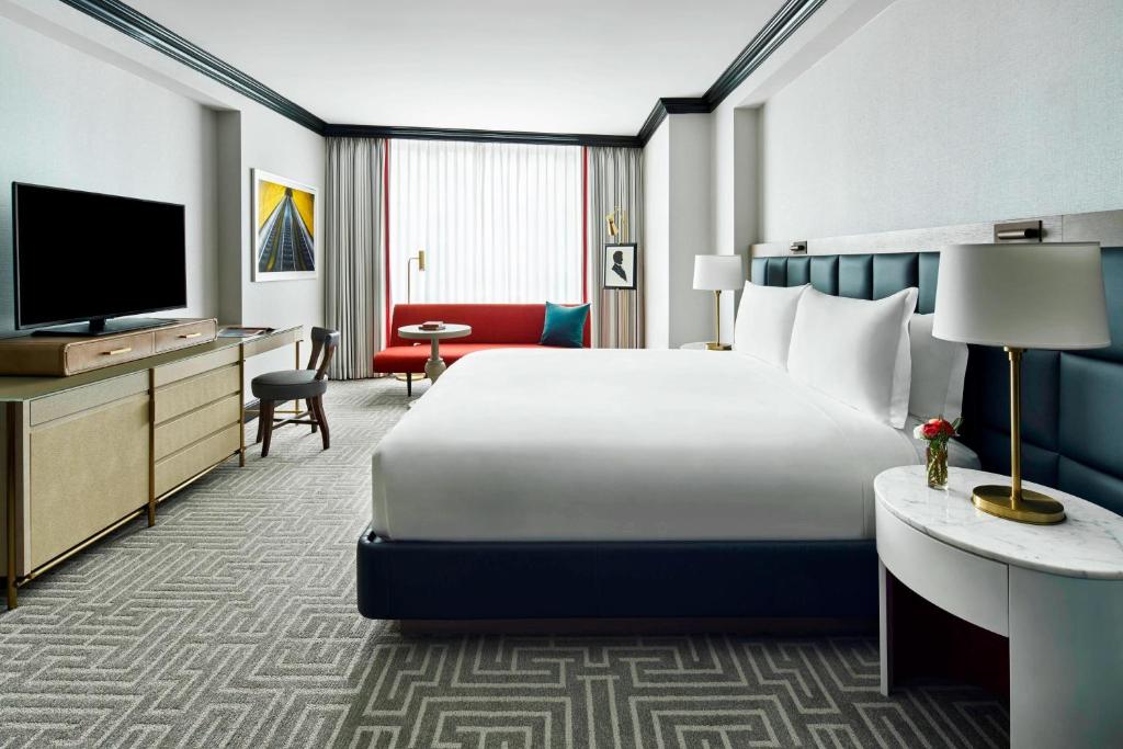 ワシントンにあるザ リッツ カールトン ワシントン D.C.の大型ベッドとテレビが備わるホテルルームです。
