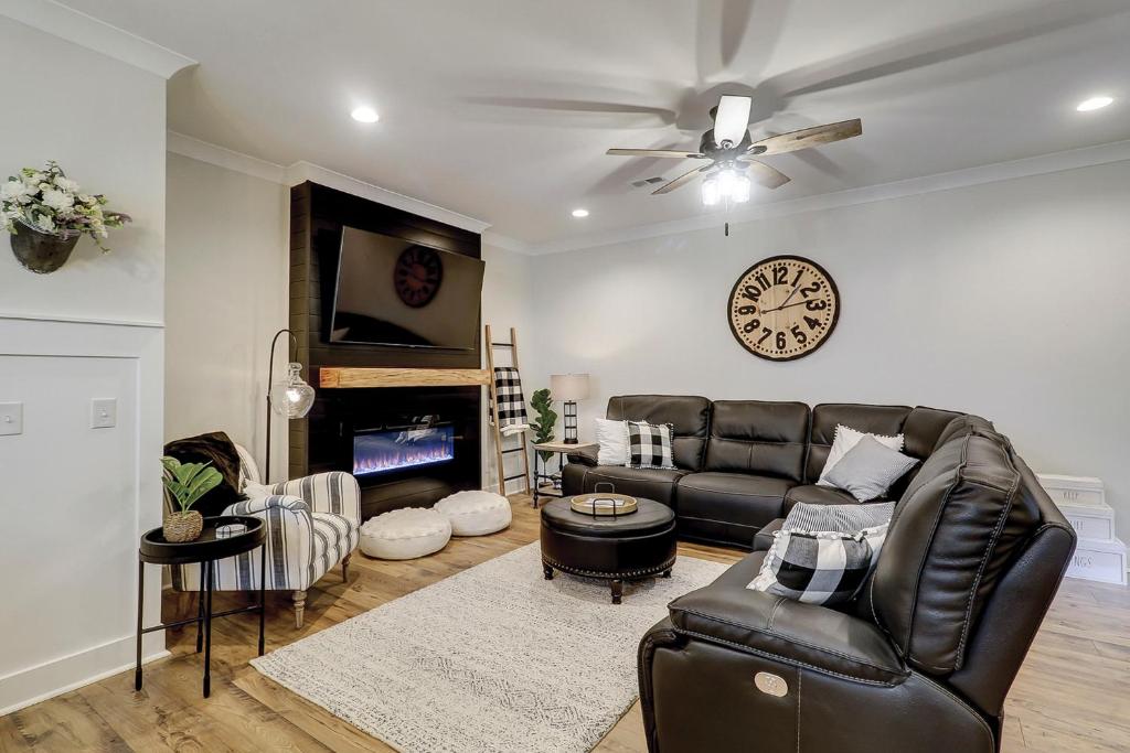 a living room with a leather couch and a clock at 4 Bed 35 BA 1K 3Q 2T Sleeper Sofa Park 3 Cars Bikes & Beach Gear included in Hilton Head Island