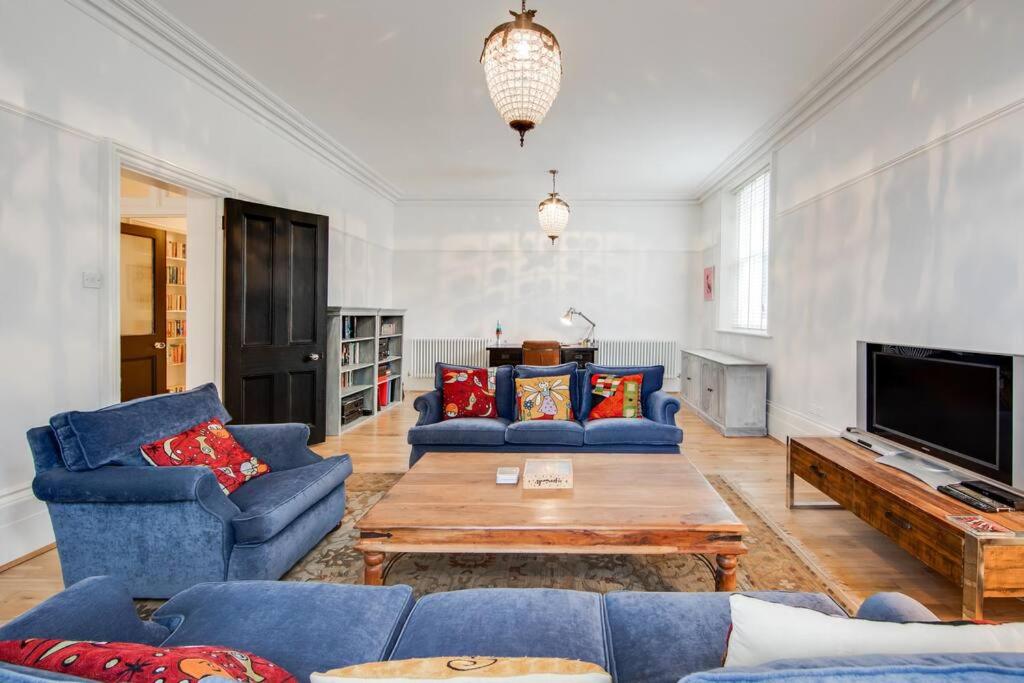 a living room with blue couches and a coffee table at Princes Villa - large fully Self Contained Flat, 5 minutes from the sea in Hastings