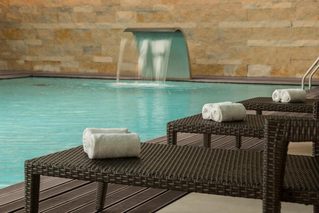 a swimming pool with two chairs and a fountain at Hotel Dom Goncalo & Spa in Fátima