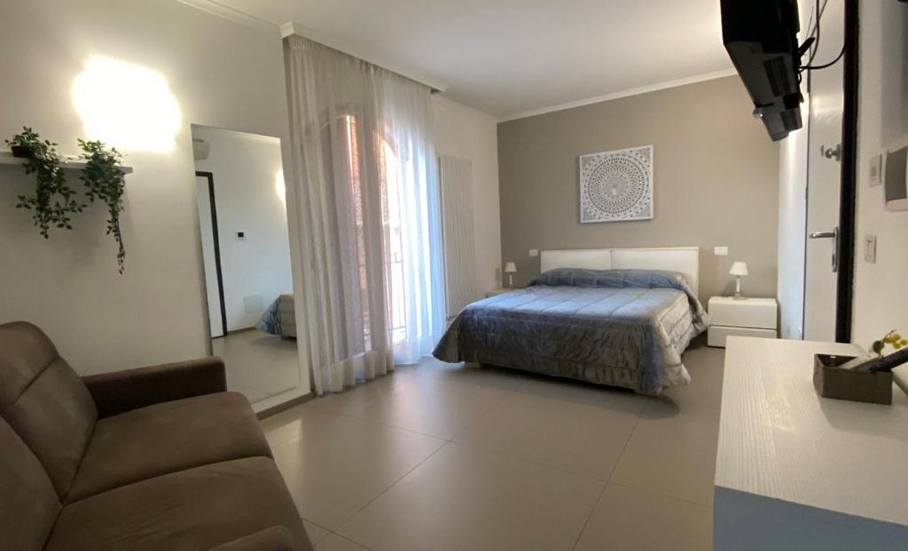 1 dormitorio con 1 cama y 1 sofá en B&B Belvedere, en Cerignola