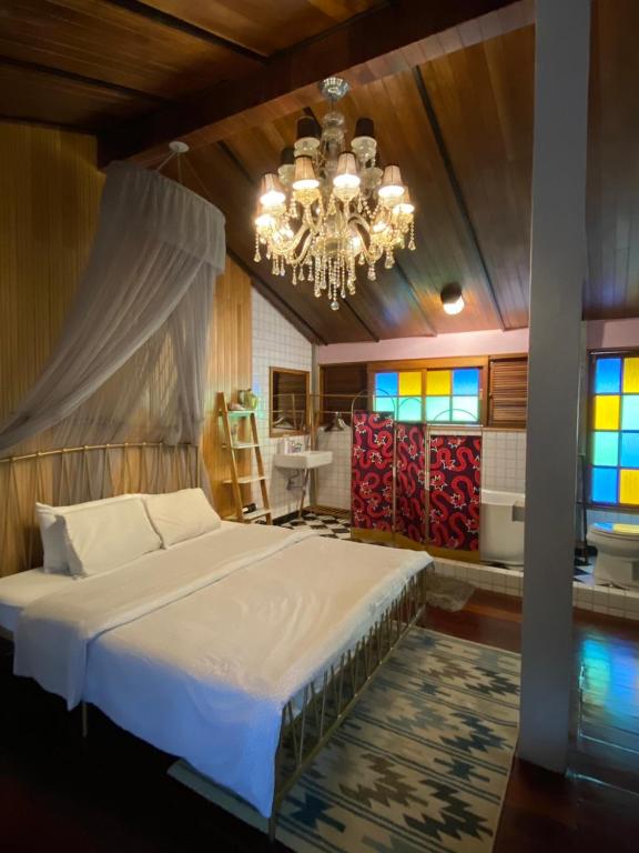 a bedroom with a large bed and a chandelier at T-House BKK 2Floors near BTS with swimming pool and free Wifi in Klong Toi