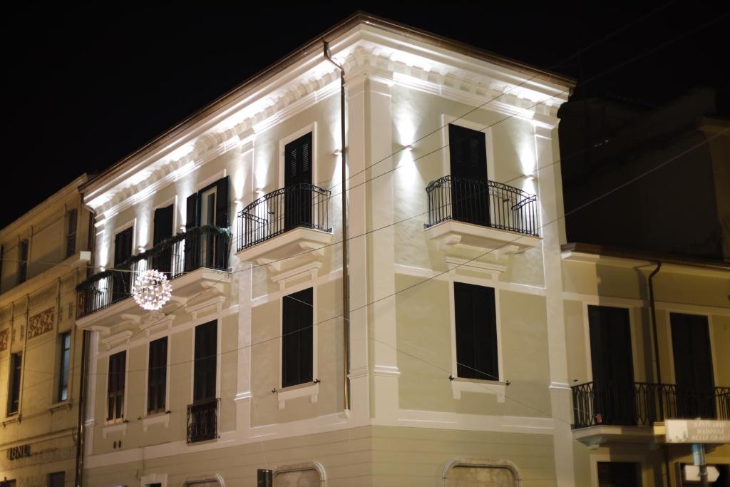 a white building with windows and balconies at night at Volsci Rooms in Sora