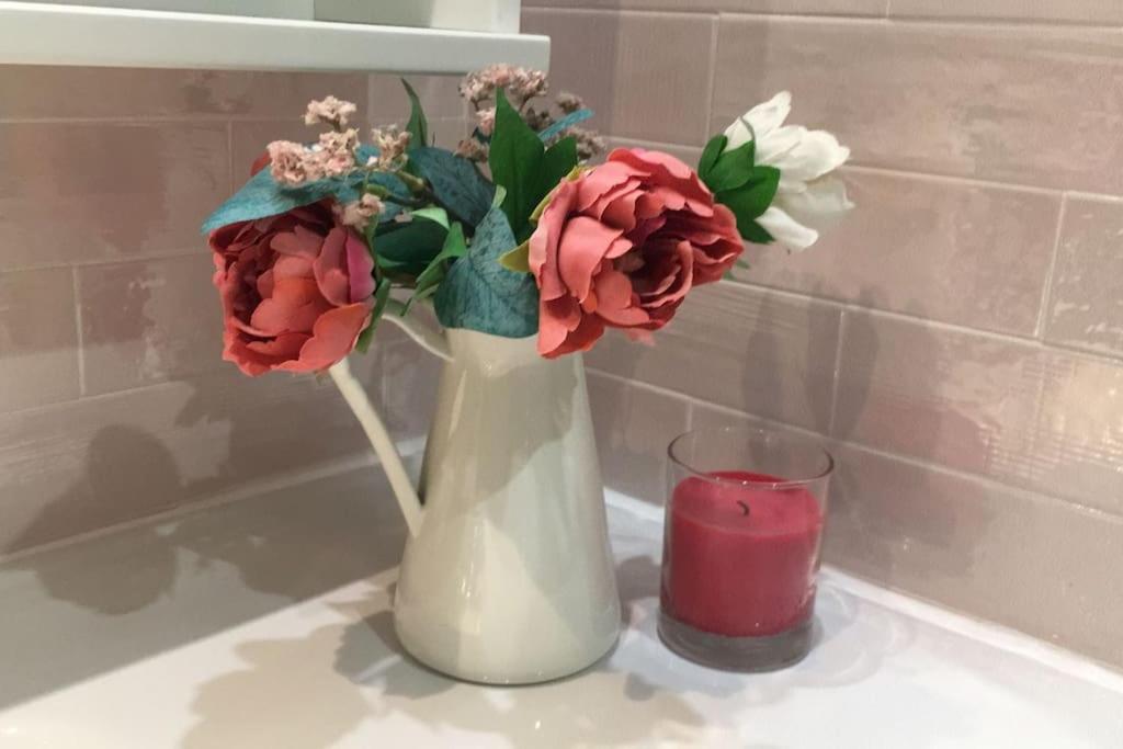 a vase with flowers and a candle on a counter at Apartamento en Navacerrada in Navacerrada