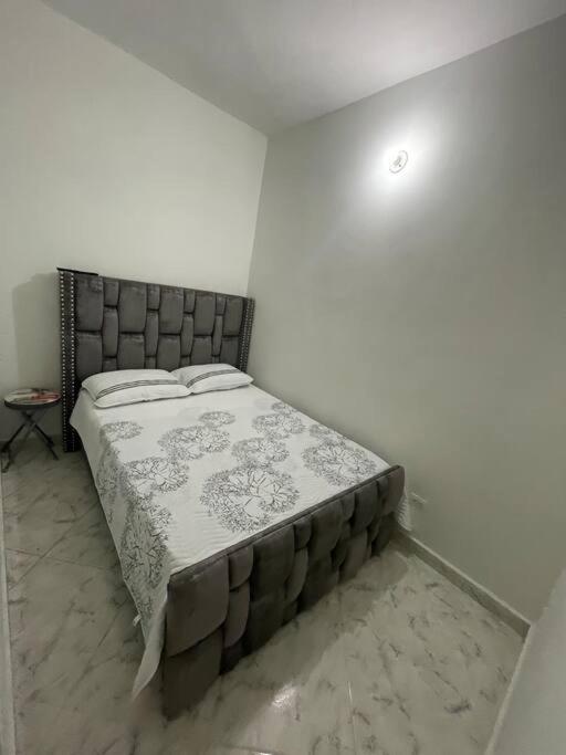 een slaapkamer met een bed in een witte kamer bij Aparta-hotel laureles 201 in Medellín