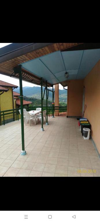 eine große Terrasse mit Tischen und einem blauen Dach in der Unterkunft Casa Dirindo in Carrodano Inferiore