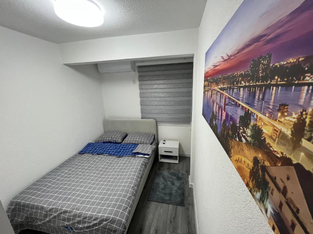 a bedroom with a bed and a painting on the wall at Apartman Bajo 1 in Foča