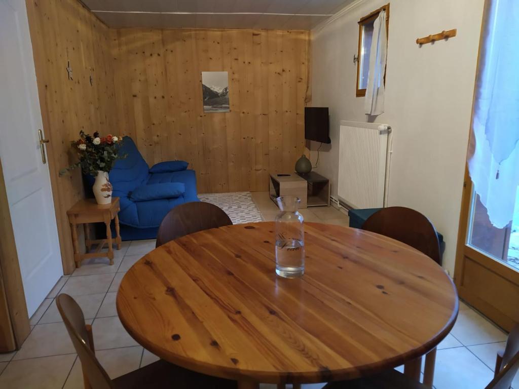 een eetkamer met een houten tafel en een blauwe bank bij Appartement dans un chalet de montagne in Guillestre