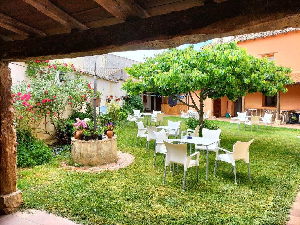 un grupo de mesas y sillas en un patio en Albergue Don Camino en Villalcázar de Sirga