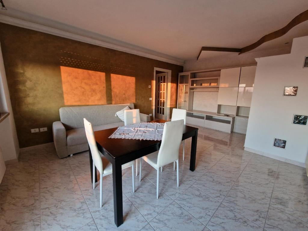 cocina y comedor con mesa y sillas en Appartamento Divino Tramonto, en Altedo