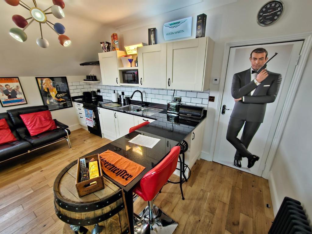 a man in a suit is standing in a kitchen at Southsea Royale James Bond 3 bed Cool Penthouse, seafront parking in Portsmouth