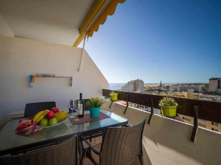 a table with a bowl of fruit on a balcony at Marlenghi Apartments 818 in San Bartolomé de Tirajana