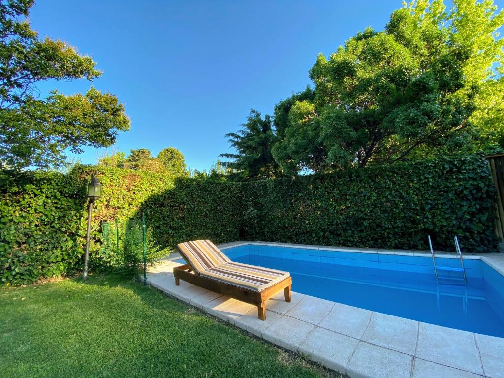 un banco sentado junto a una piscina en Berdina Loft House, Chacras de Coria en Chacras de Coria