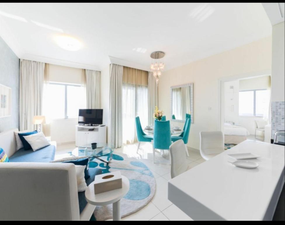a living room with white furniture and a blue rug at OSKENA Vacation Homes - Damac Maison Dubai Mall Street in Dubai