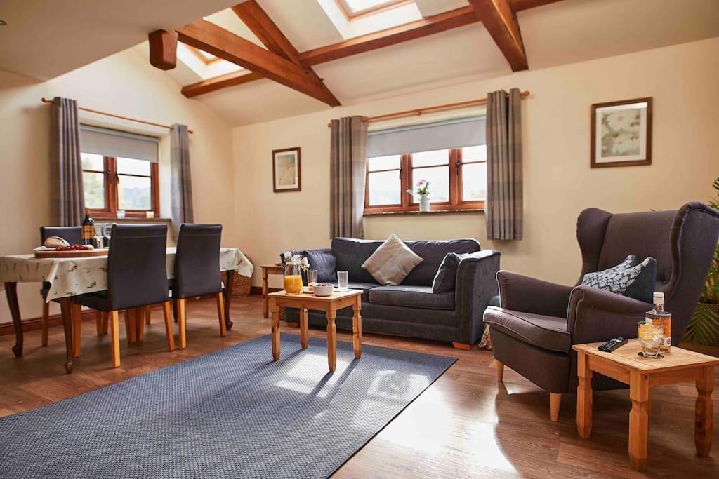 - un salon avec un canapé et une table dans l'établissement Bentra - Boutique Cottage at Harrys Cottages, à Pen y Clawdd