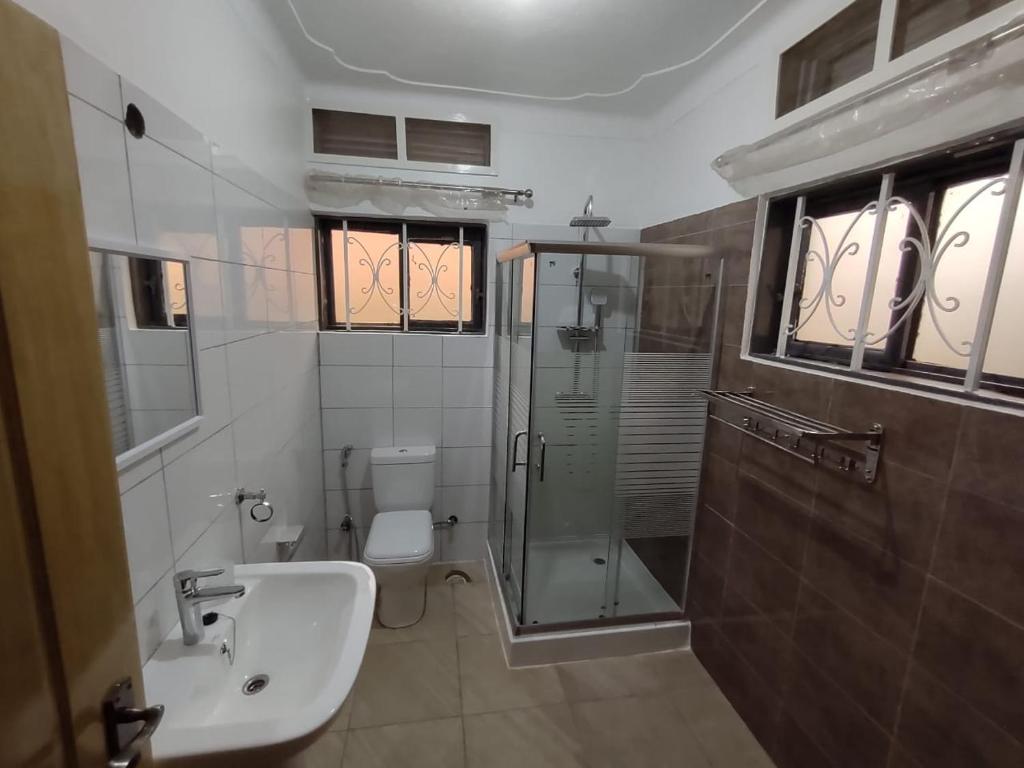 uma casa de banho com um chuveiro, um lavatório e um WC. em Stand alone gateway em Kampala