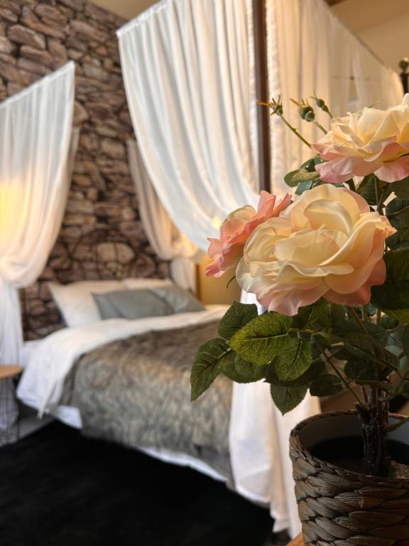 - une chambre avec un lit et un vase avec des fleurs dans l'établissement Esprit ALSACE: 70m2 de charme, à Mulhouse