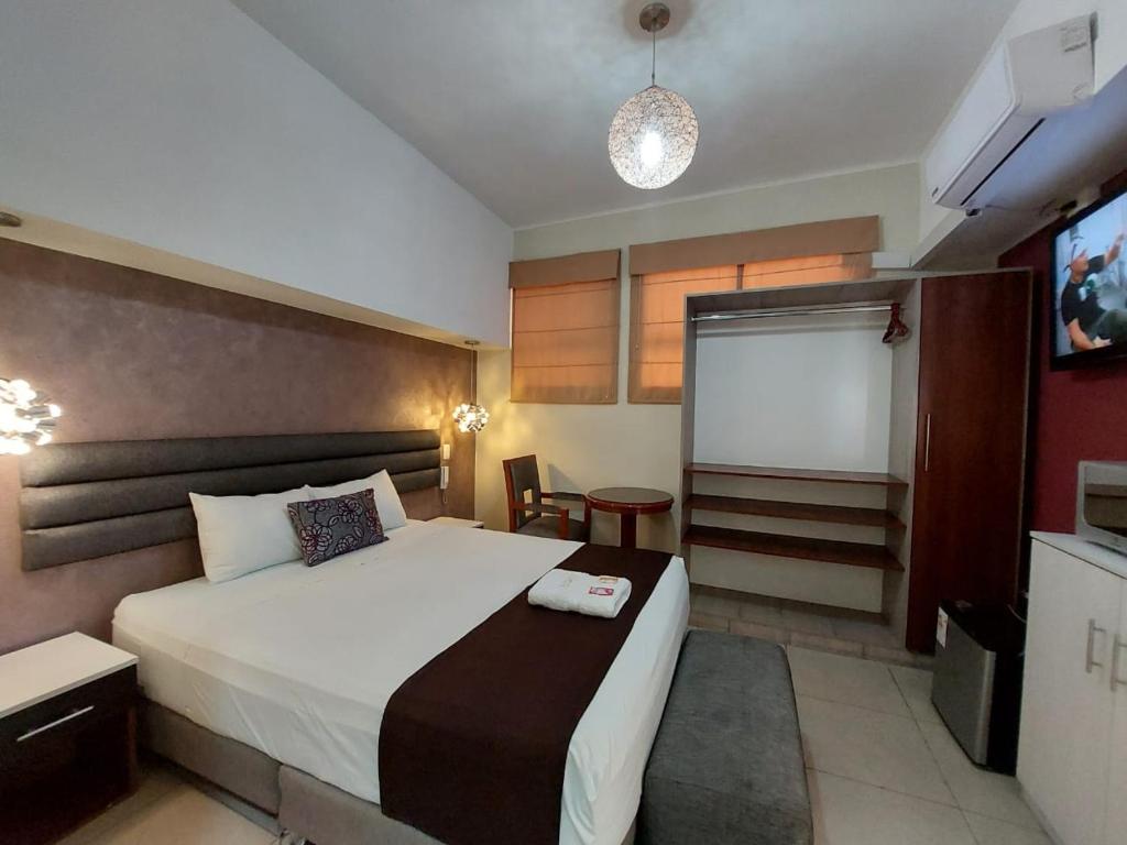 a hotel room with a bed and a tv at Hostal Atenea in Ilo