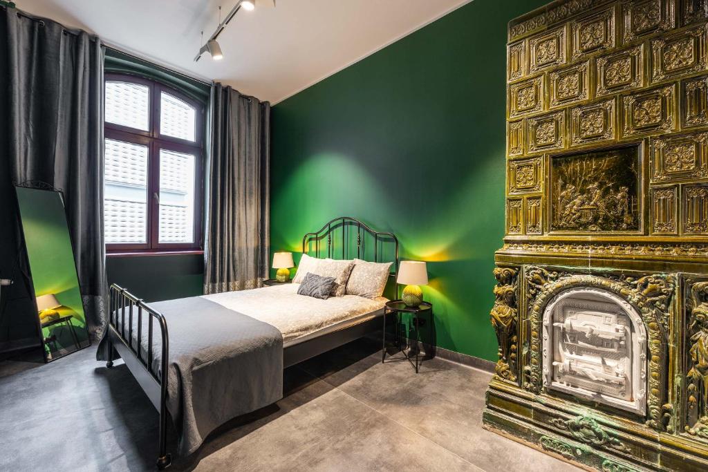 a green bedroom with a bed and a fireplace at LivingRoom 2 Heritage Hydromassage Bath Self Check-in 24h in Katowice
