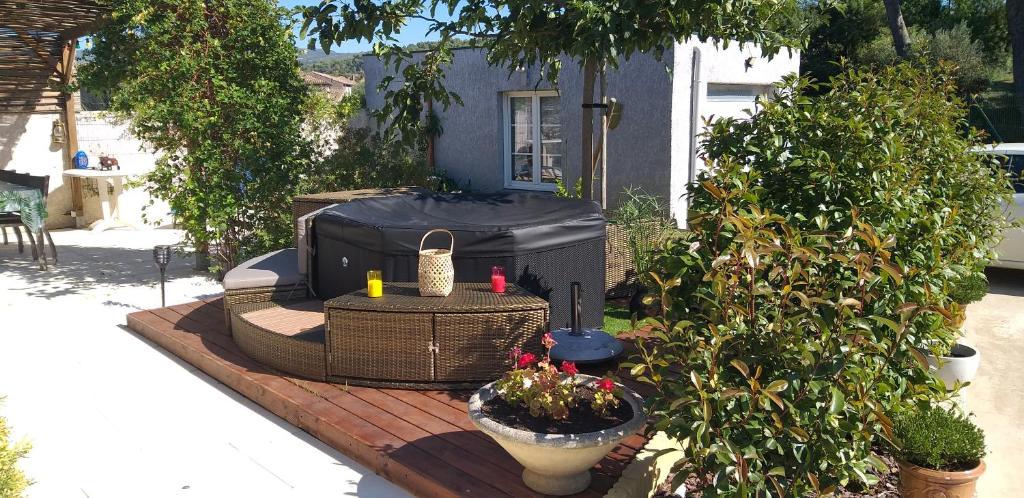 un patio con parrilla y una mesa con plantas en Chez Reinette en Capendu