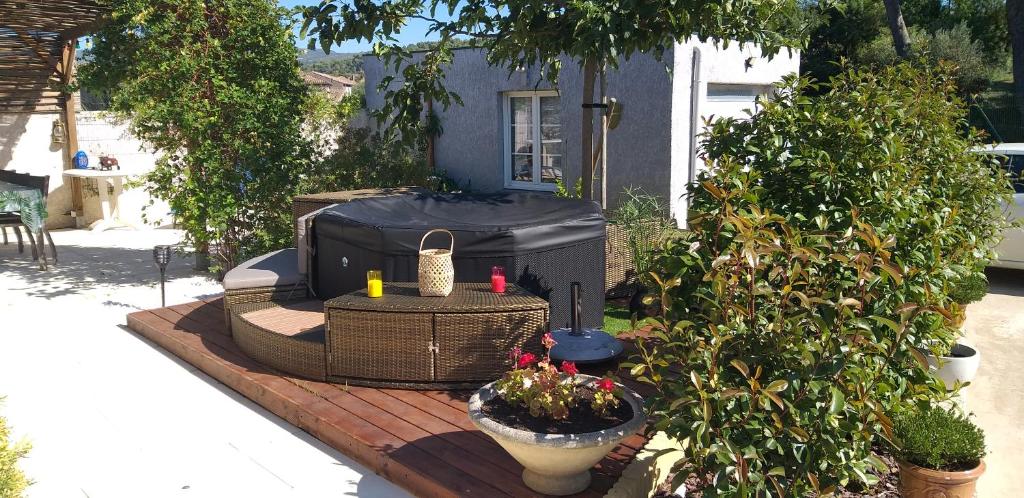 um pátio com comodidades para churrascos e uma mesa com plantas em Chez Reinette em Capendu