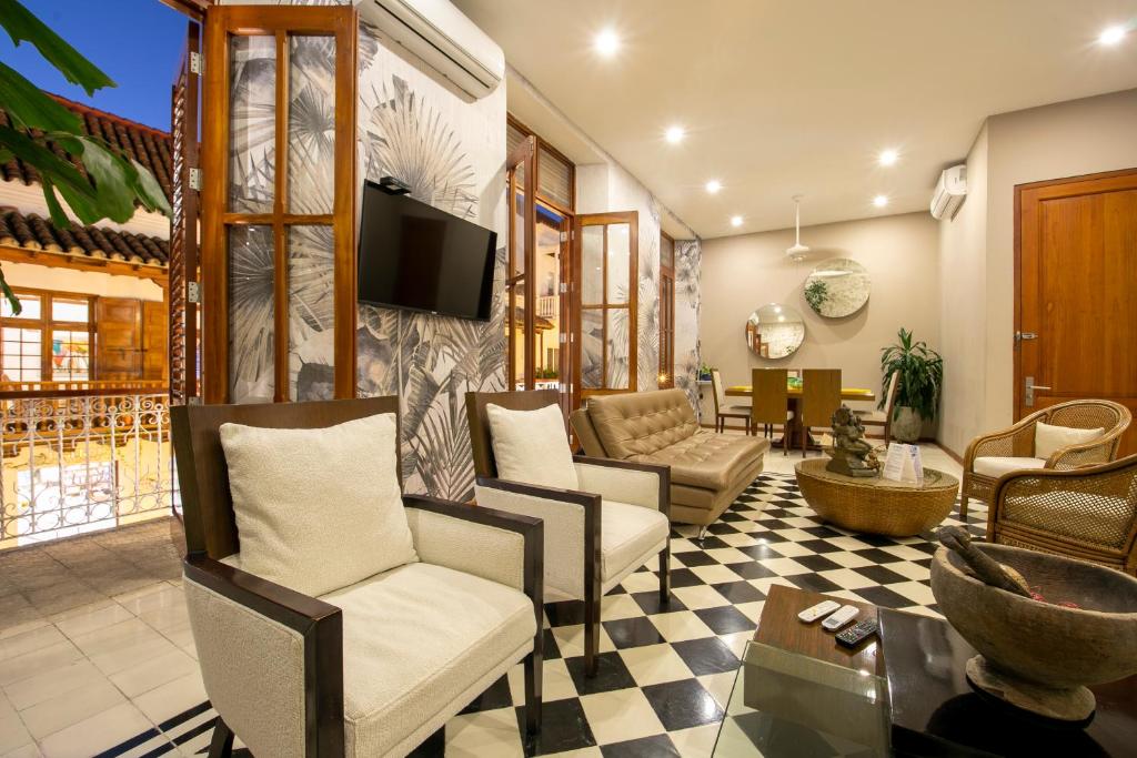 ein Wohnzimmer mit Stühlen und einem TV an der Wand in der Unterkunft San Pedro Claver Luxury in the walled city in Cartagena de Indias