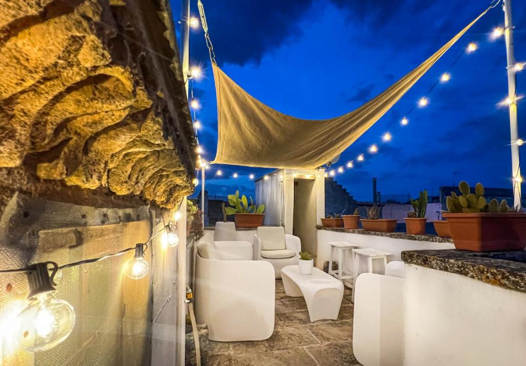 eine Terrasse mit weißen Möbeln und nachts Licht in der Unterkunft Luxury house Corte dei Galati in Galatone