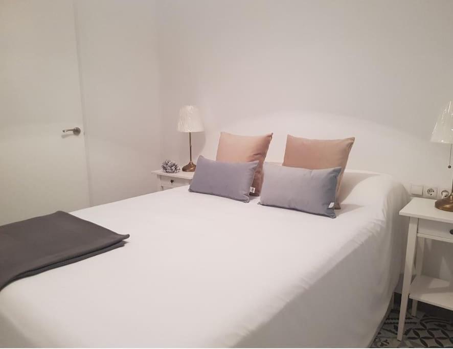 un letto bianco con tre cuscini sopra di Casa Rural Los Naranjos a Constantina