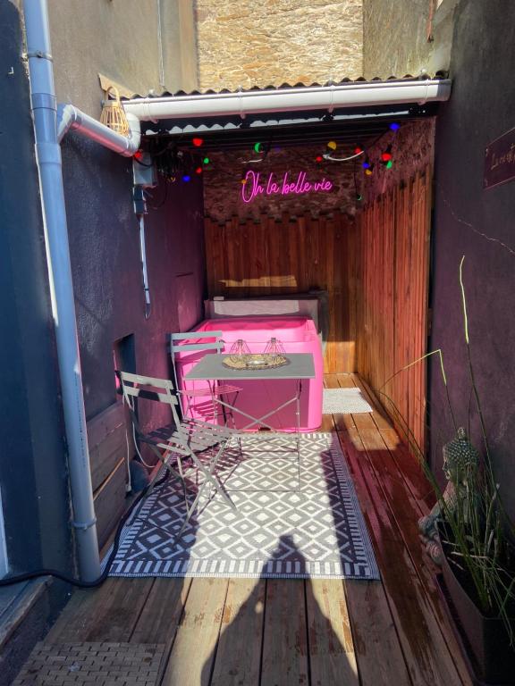 un patio con una cama rosa y una mesa en Appartement cosy à Nantes avec terrasse, en Nantes