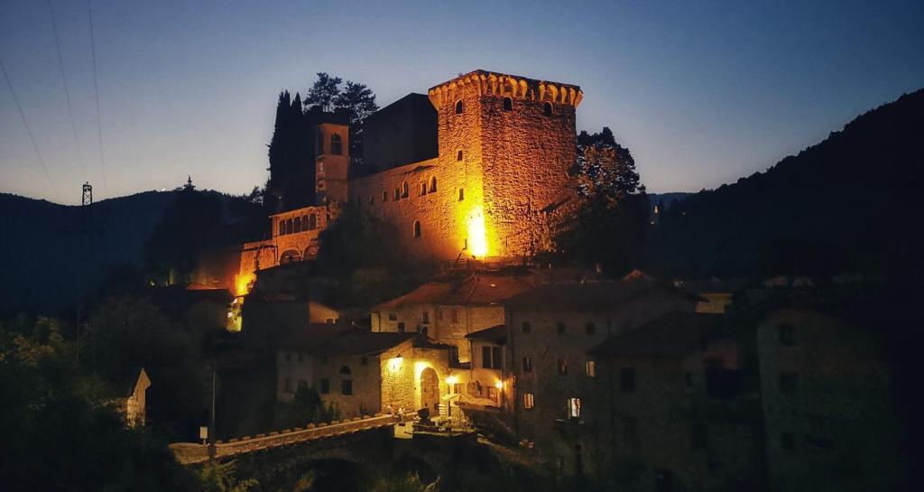 un castillo sentado en la cima de una colina por la noche en Casa Vacanze CAROLE, en Fivizzano