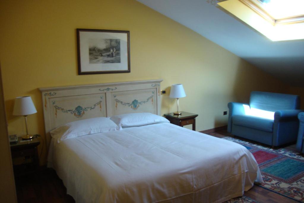 1 dormitorio con 1 cama blanca y 1 silla azul en Hotel La Loggia, en Mestrino