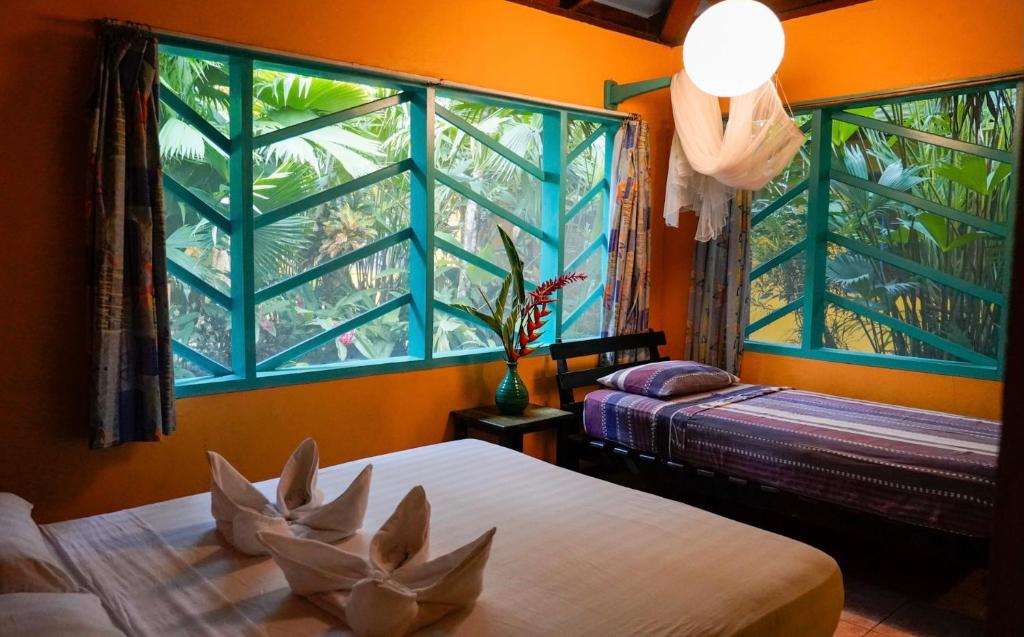 プエルト・ビエホにあるCabinas Guaranaのベッドルーム1室(ベッド2台、大きな窓付)