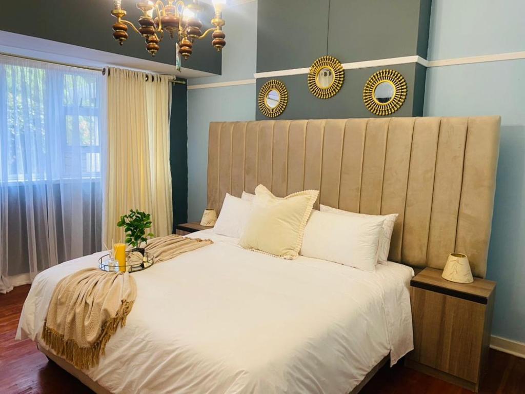a bedroom with a large bed with a large headboard at Paradise Guest House in Roodepoort