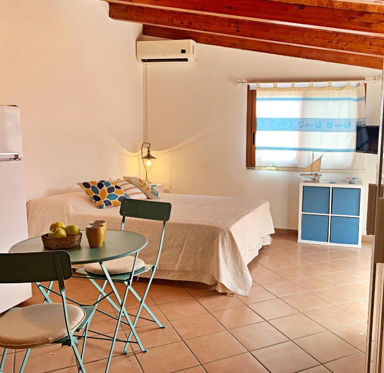 a bedroom with a bed and a table and chairs at DomoMea - Le Gioie di Laura in Su Forti