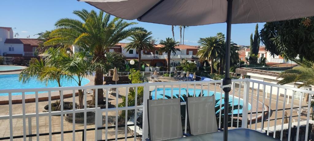 a balcony with a view of a pool and palm trees at Casa Armonía del sol in San Bartolomé de Tirajana