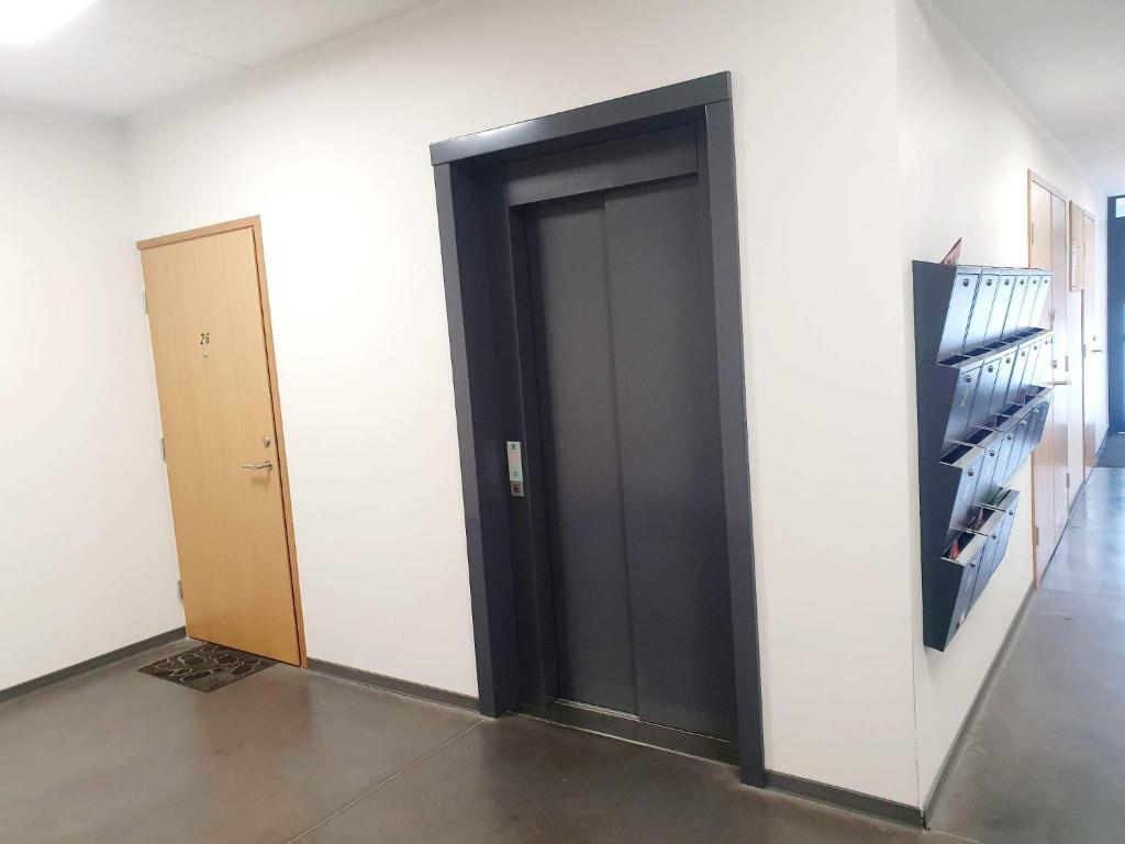 uma porta preta num quarto branco com uma prateleira em Kasekodu apartament em Laagri