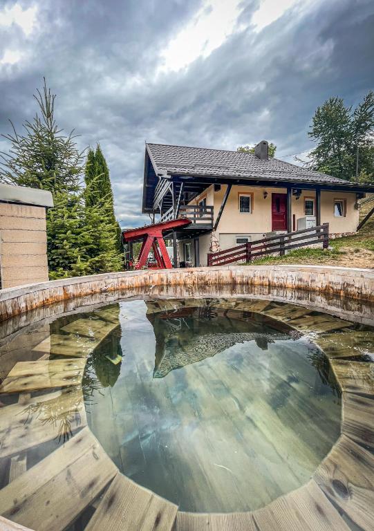 a bridge over a pond in front of a house at Cabana La Coco Horea in Arada