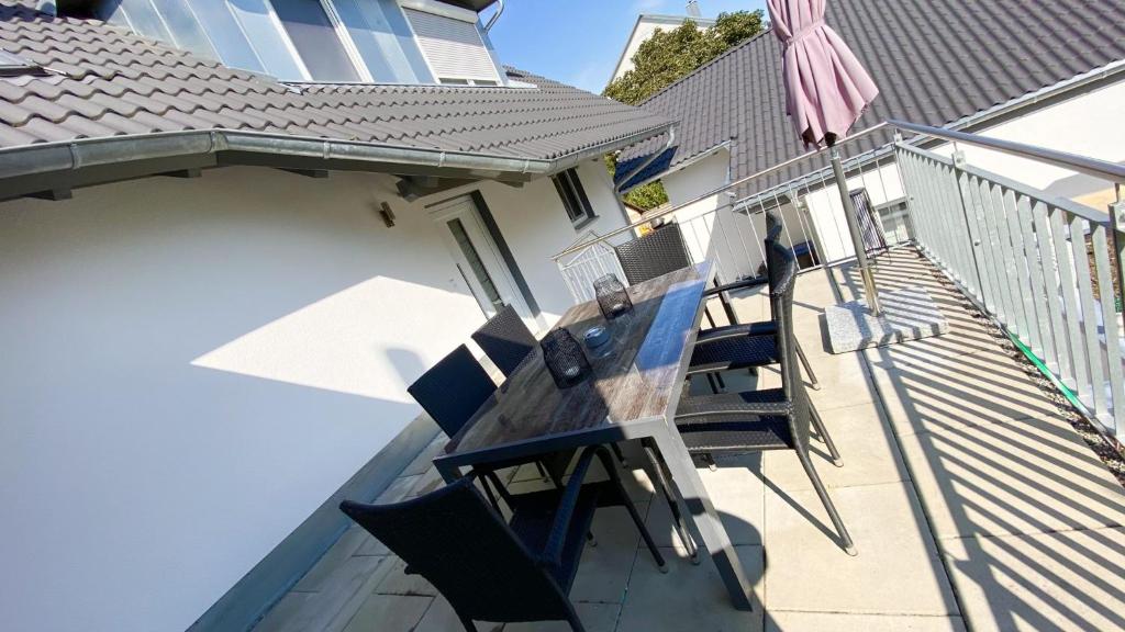 a deck with a table and chairs on a balcony at Ferienwohnungen Zur Abtei Bodenseeregion in Ravensburg