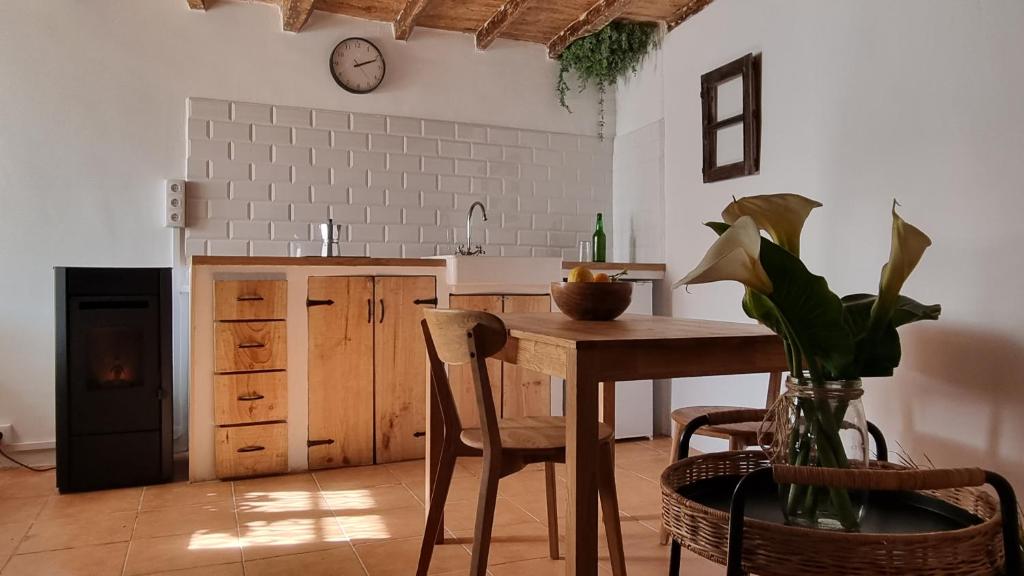 a kitchen with a table and chairs and a clock on the wall at El rinconin del Sueve in San Martín